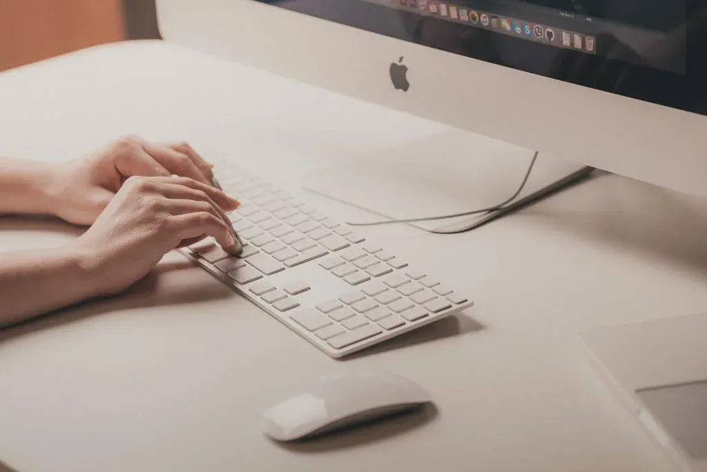 Someone typing on a Mac keyboard